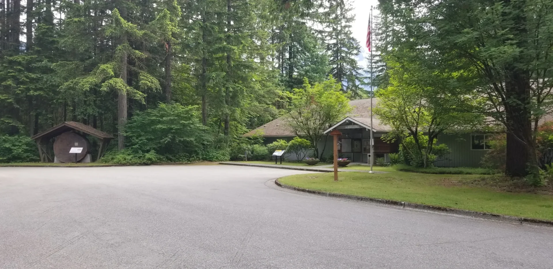 A house with trees in the background and a street sign.