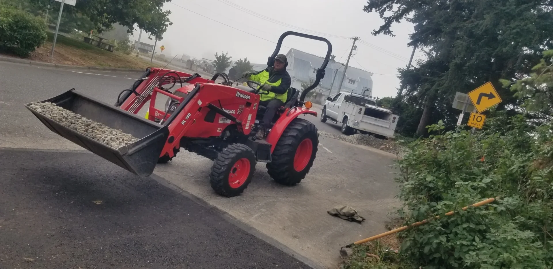 A man riding on the back of a tractor.