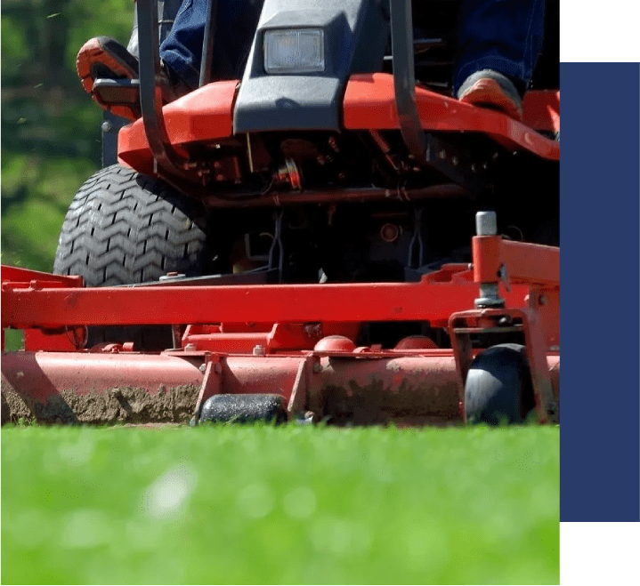 A person on a lawn mower in the grass.